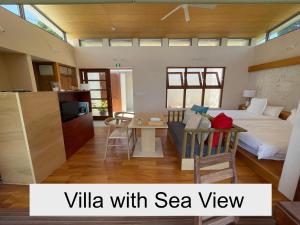 a bedroom with a bed and a kitchen with a table at 水と共に過ごすスモールヴィラ　かふーわ知念　 in Chinen +20 photos