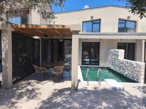 a house with a swimming pool in front of a house at Elaida suites in Prinos