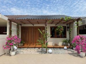 a porch of a house with pink flowers at Shinju Villa with Jacuzzi Pool in Jelutong