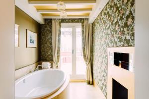 a bathroom with a large tub and a window at Papadopoli Hotel Venezia - MGallery Collection in Venice +94 photos