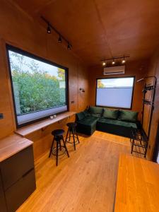 a living room with a green couch and a large window at Domek Surf Camp in Jastarnia
