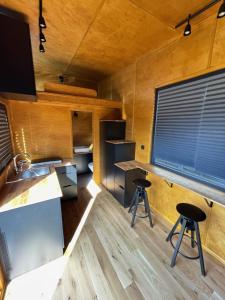 a kitchen in a tiny house with two stools at Domek Surf Camp in Jastarnia