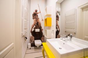 a bathroom with a sink and a woman in a mirror at Apartamenty NEPTUN in Poznań +31 photos