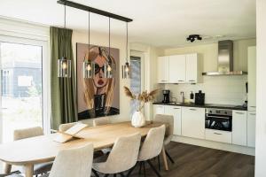 a kitchen and dining room with a table and chairs at Wetterfrij - Enjoying the water in Elahuizen in Elahuizen