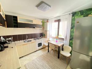 a small kitchen with a table and a refrigerator at Vila Luna in Năvodari