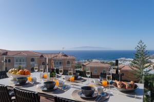 een tafel met eten en wijnglazen op een balkon bij Karat Villa Sand in Adeje