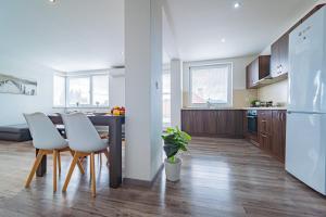 una cucina e una sala da pranzo con tavolo e sedie di Luxusný, plne zariadený, súkromný apartmán s klimatizáciou neďaleko historického kúpeľného mesta Bojnice a Nováky Altre 49 foto