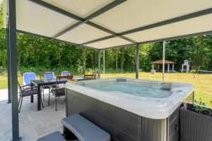 a hot tub in a patio with a table and chairs at Villa DE Luna Istra,whirlpool in Barban