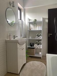 a white bathroom with a sink and a mirror at Vila Luna in Năvodari +21 photos