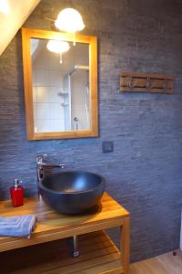 ein Badezimmer mit einem schwarzen Waschbecken und einem Spiegel in der Unterkunft Studiowohnung mit dem gemütl Flair in Döse + 24 Fotos