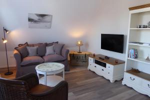 ein Wohnzimmer mit Sofa und Fernseher in der Unterkunft Studiowohnung mit dem gemütl Flair in Döse