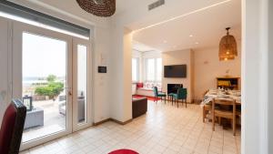 Villa Petronilla sul Mare by Rentbeat في سافيلّيتري دي فاسانو: غرفة معيشة مع طاولة وغرفة طعام