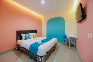 a bedroom with a large bed and a desk at Sans Hotel Harapan Indah in Pulokendal +25 photos