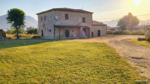 an old stone house on a grassy hill at L'Antico Borgo di Leonardo in Monte San Biagio