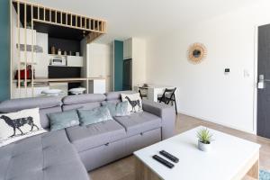 a living room with a couch and a table at Le Marnier - Moderne & Central in Montaigu-Vendée