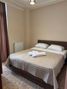a bedroom with a bed with two towels on it at Tiko's Apartments in Gonio in Gonio