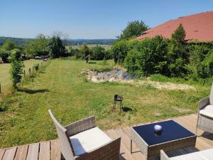 a patio with a table and chairs and a field at Tiny escapade in Dombasle-devant-Darney