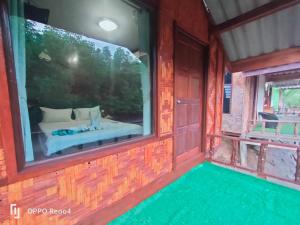 a room with a bed and a large window at saithai forest homstay in Krabi