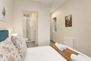 a bedroom with a bed with two towels on it at Sunset On Hill 3 in Bloubergstrand
