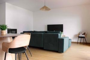 a living room with a blue couch and a table at Torreira Beachside House in Torreira