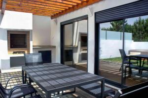 a patio with a table and chairs on a deck at Torreira Beachside House in Torreira