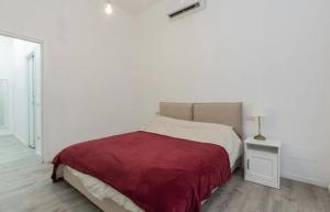 a white bedroom with a bed with a red blanket at I-Host Apartment - Gallura 11-2 in Milan