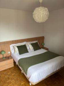 a bedroom with a large bed and a chandelier at La Piragua in Ribadesella