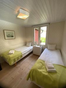 a bedroom with two beds and a window at Ljusterö Logi in Norra Ljustero