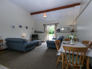a living room with blue furniture and a table at Florence Cottage in Holyhead
