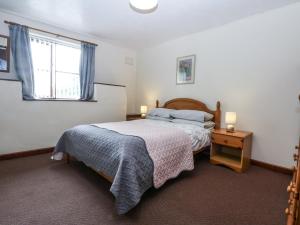 a bedroom with a bed and a window at Florence Cottage in Holyhead