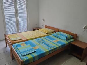 a bedroom with two beds and two windows at Apartman Čolović in Sutomore