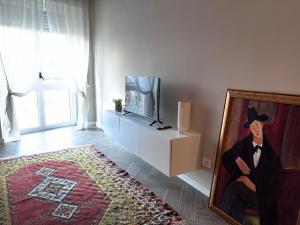 a living room with a painting of a man at Vista con camera - appartamento Grignolino in Casale Monferrato