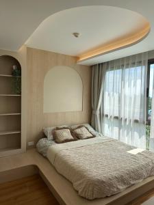 a bedroom with a large bed and a large window at Fantasea Condo Kamala in Kamala Beach +16 photos