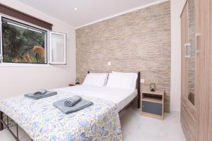 een slaapkamer met twee bedden en een raam bij Rena's House, Viros, Corfu in Corfu