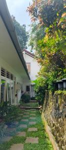 a stone walkway next to a white house at Kalyana Guest House in Bandung