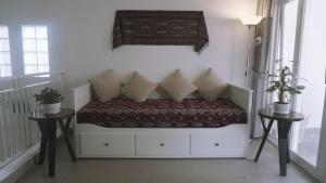 a room with a bed with pillows and two tables at Kalyana Guest House in Bandung