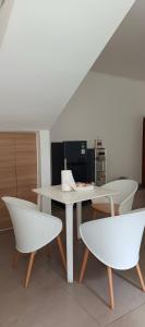 a white table and two chairs in a room at Kalyana Guest House in Bandung