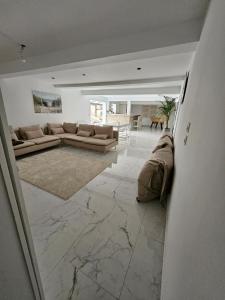 ein Wohnzimmer mit Sofa und Tisch in der Unterkunft Maison dans corps de ferme Aéroport beauvais 14 minute 