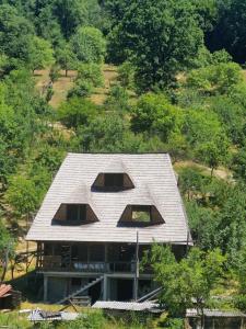 una casa con techo en la cima de una colina en La Mona, en Bîrsana