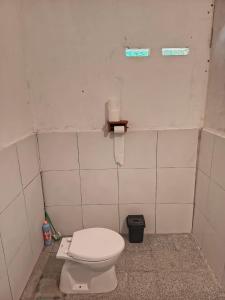 a bathroom with a white toilet in a stall at Hendi Homestay in Gili Gede