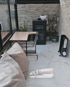 eine Terrasse mit einem Tisch und einem Stuhl und einem Lautsprecher in der Unterkunft Maison dans corps de ferme Aéroport beauvais 14 minute 