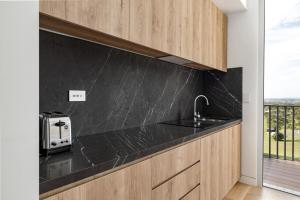 a kitchen with a black counter top and a sink at Mount View Estate One Bedroom Country Stay The Olive Escape in Mount View