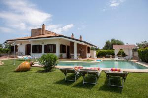 a house with a pool and chairs and a house at Villa Ellea in San Michele Salentino