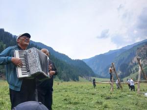 a woman playing an accordion in a field at Aidar in Arkit