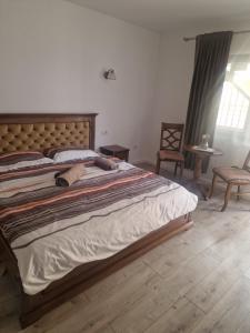 a bedroom with a large bed with a wooden headboard at La Mona in Bîrsana