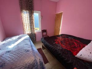 a bedroom with a bed and a window at erekle guest house in Mestia