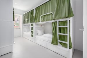 a room with bunk beds with green curtains at Boavista 83 Hostel Lisbon in Lisbon
