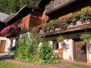 a house with flowers on the side of it at Bergromantik Ferienwohnung Charme mit einer Infrarotkabine und Bergblick in Marktschellenberg