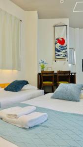 2 letti con asciugamani in una camera da letto di R Inn岸里 R-Inn Kishinosato ad Osaka