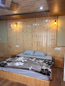 a bedroom with a bed in a wooden wall at TY Homestay Sissu By Soma Stays in Sissu
